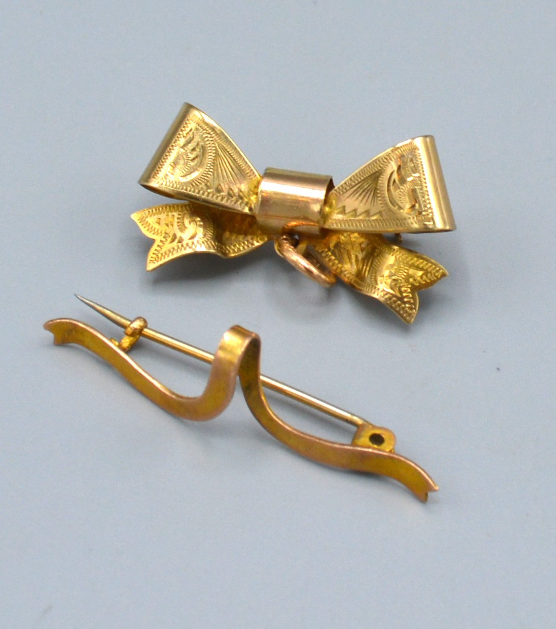 A 9ct. Gold Brooch in the form of a Bow together with another similar 9ct. gold brooch, 3.7 gms.