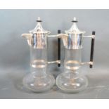 A pair silver plated and glass claret jugs in the style of Christopher Dresser with ebonies handles,