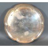 A Sheffield Silver Presentation Salver of shaped outline with three ball and claw feet, 28 ozs. 31.5