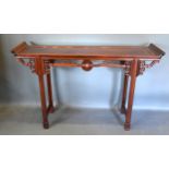 A Chinese Hardwood Altar Table, the shaped top with scroll ends above a carved frieze with central