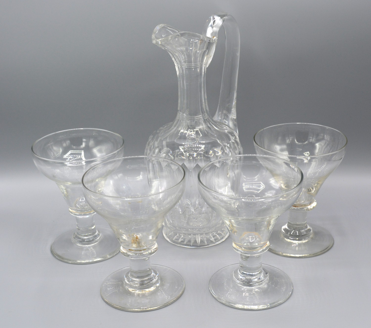 A Cut-Glass Jug with shaped handle together with four early glasses with tapering bowls and circular