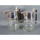 A Pair of Silver Plated and Cut Glass Claret Jugs in the style of Christopher Dresser, the hinged