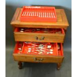 A Silver Plated Canteen of Cutlery housed within a Chinese hardwood four drawer chest with brass