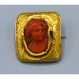 A Small Rectangular Brooch the carved coral centre in the form of a classical figure 2 x 1.5 cms