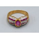 A 9ct. Gold Ruby and Diamond Ring with central oval ruby flanked by bands of rubies and diamonds,