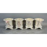 A set of four silver plated bottle coasters of pierced form, each with three scroll feet, 12cms tall
