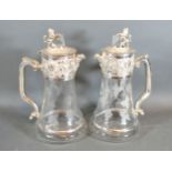 A Pair of Silver Plated and Engraved Glass Claret Jugs each with lion and shield mounts with