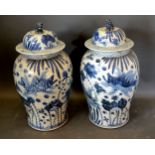 A Pair of Chinese Underglaze Blue Decorated Covered Vases, the covers with dogs of fo surmount and