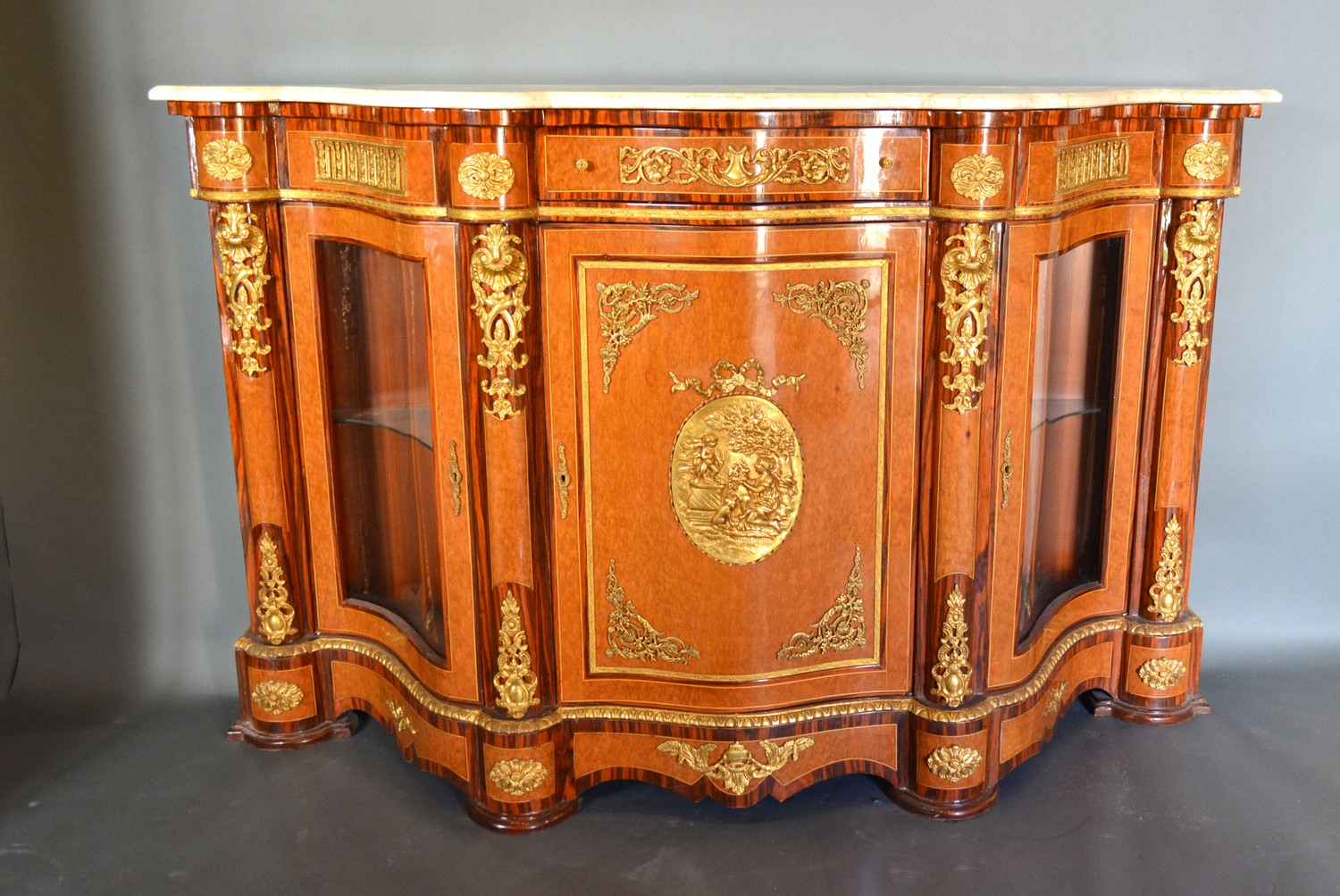 A French style walnut, gilt metal mounted serpentine Credenza cabinet, the variegated marble top