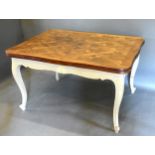 A French Oak and Painted Draw Leaf Extending Dining Table, the inlaid top above a shaped frieze