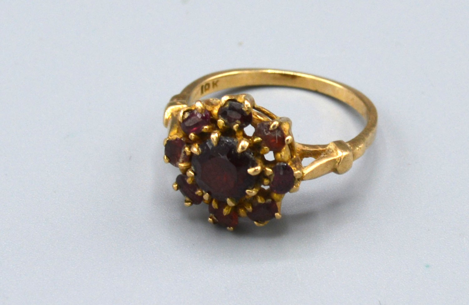 A 9ct Yellow Gold Cluster Ring set with garnets within a pierced setting, 2.7 gms Size M