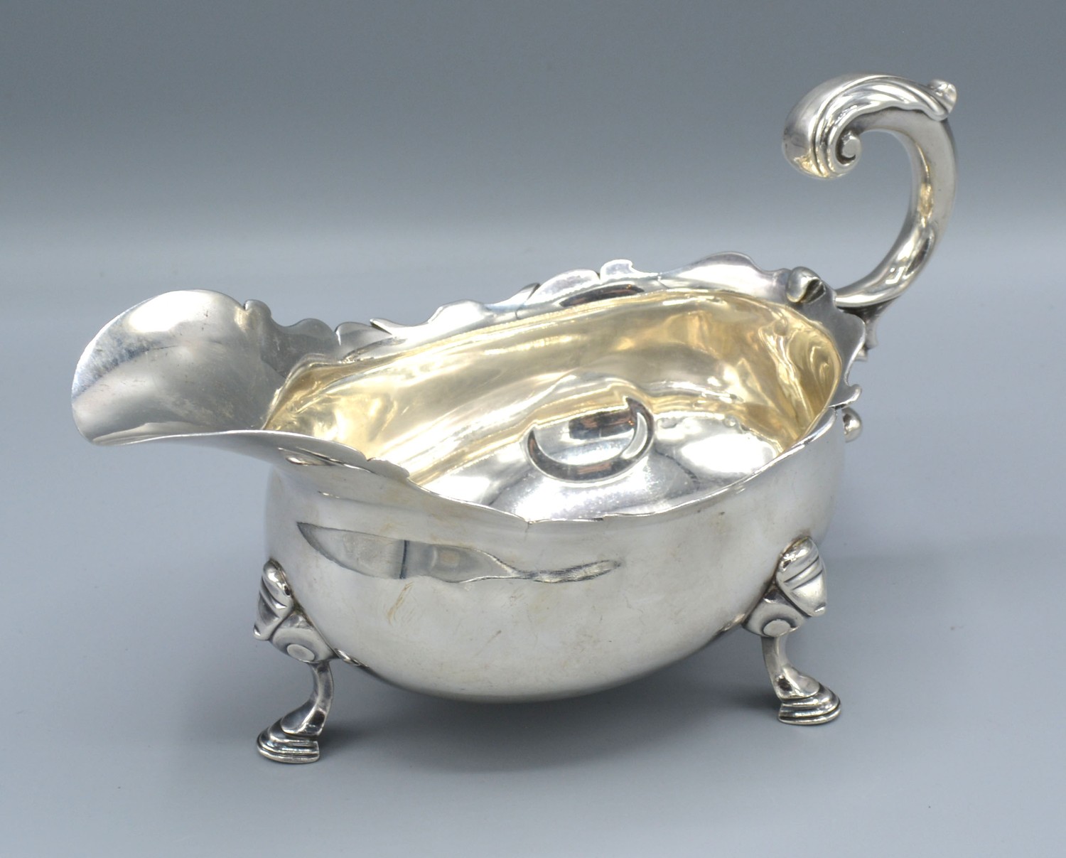A George II Silver Sauce Jug with shaped scroll handle and three hoof supports, London 1746, 12 ozs.