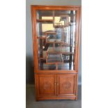 A Chinese Hardwood Display Cabinet with a glazed door enclosing various alcoves and shelving, the