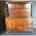 A George III Oak Dresser, the boarded shelf back above three frieze drawers and a central panel