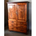 An Early 19th Century Mahogany Linen Press, the moulded cornice above two panelled doors enclosing a