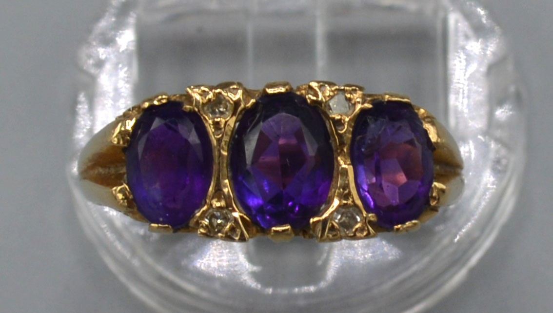 A 9ct. Gold Dress Ring set three amethysts interspaced with diamonds within a pierced scroll - Image 2 of 2