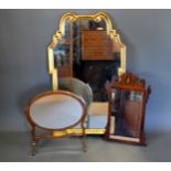 A Gilt Framed Wall Mirror of shaped form 105 cms high, 63 cms wide together with an oval swing frame