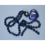 A Lapis Lazuli Pendant of Heart Form with yellow metal ring together a Lapis Lazuli bead necklace