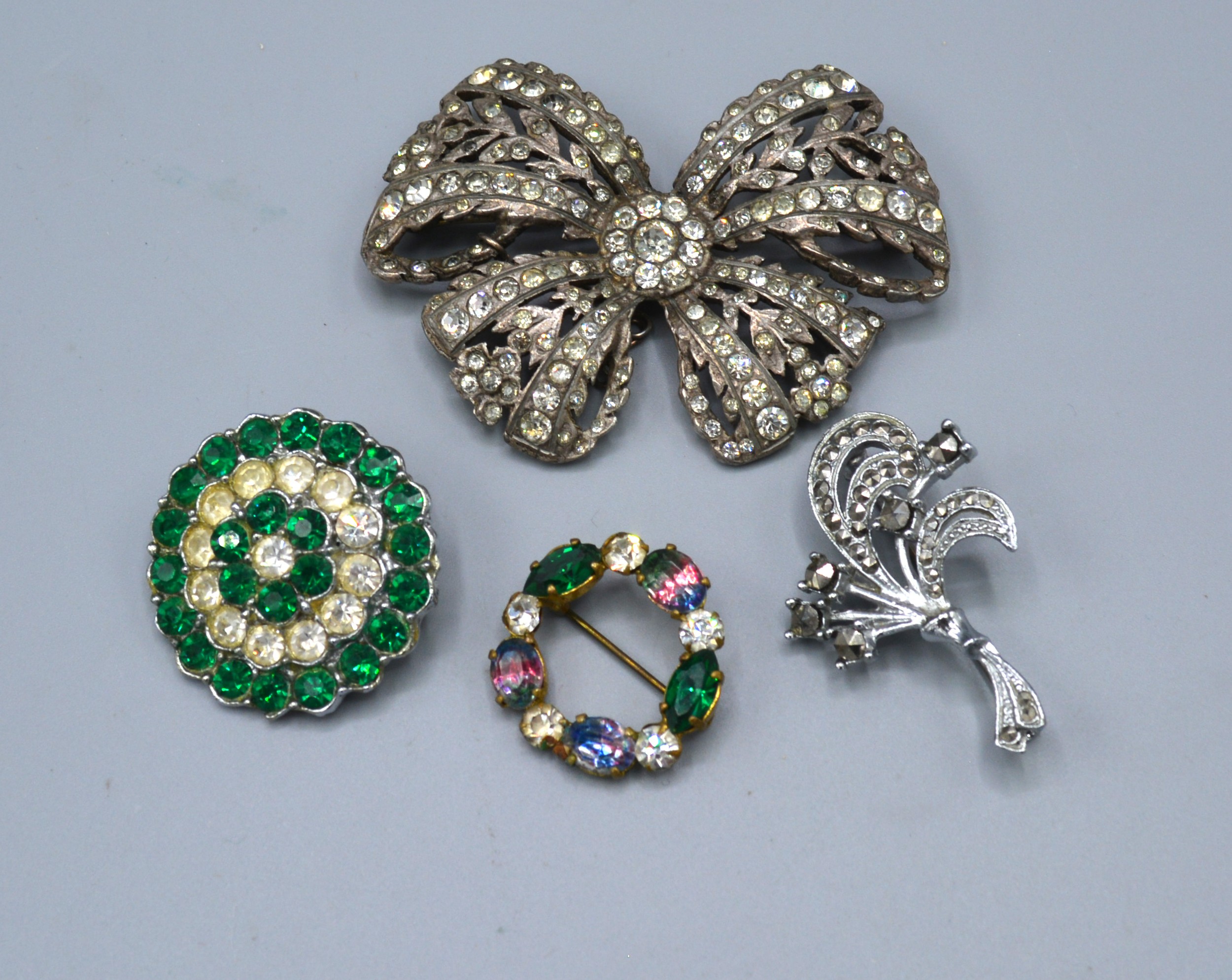 An Art Deco Style Paste Brooch together with three other similar brooches