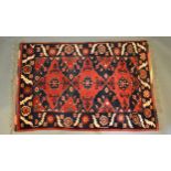 A North West Persian Woollen Rug with an all over design upon a blue red and cream ground within