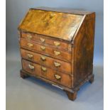 A George I Walnut Bureau, the fall front enclosing a fitted interior above four long drawers with