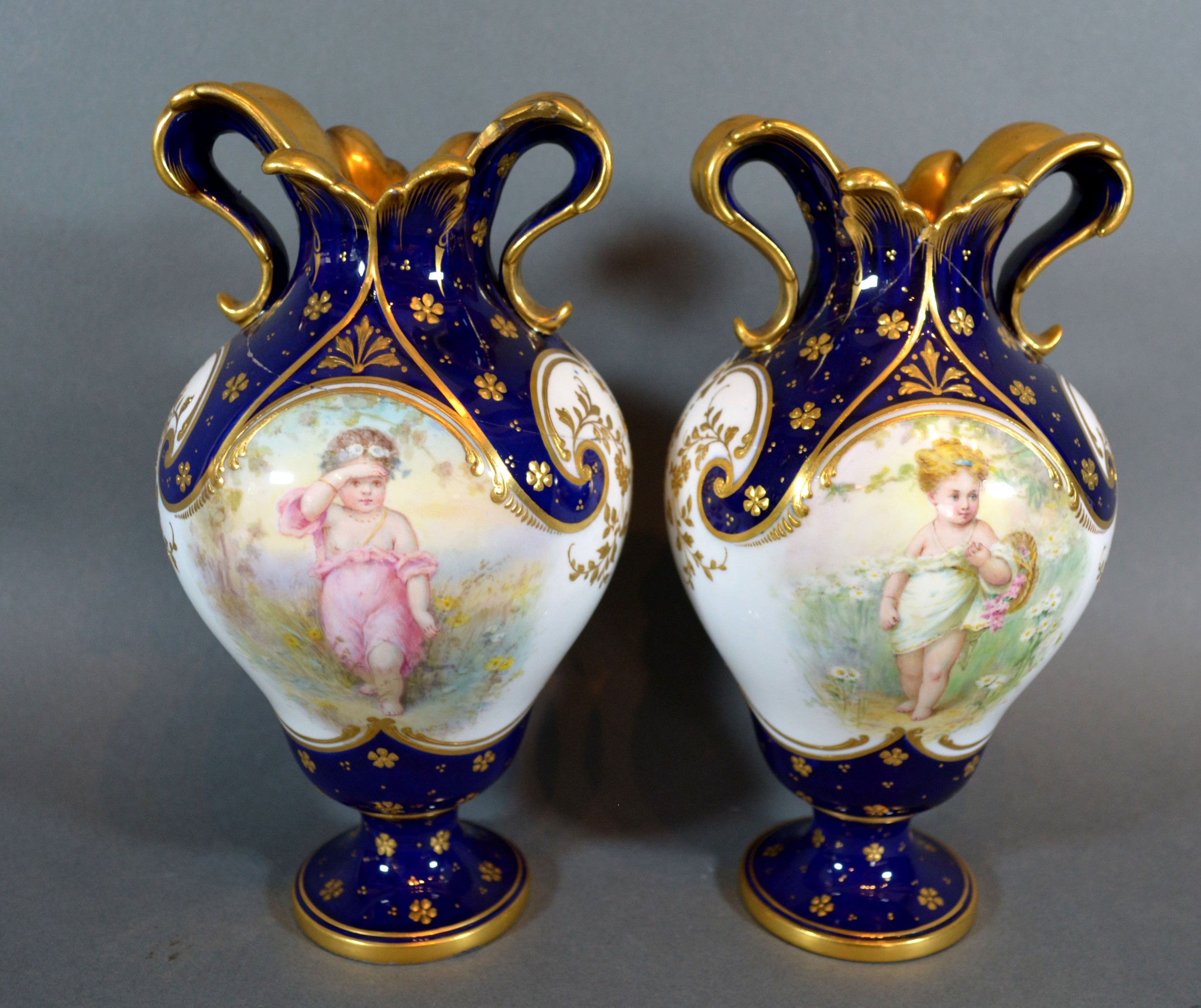 A Pair of Mintons Porcelain Vases of oviform hand painted with putti upon a cobalt blue and white