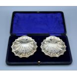 A Pair of Edwardian Silver Butter Dishes of embossed scallop pierced form within fitted lined