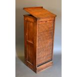 A Late Victorian Oak Clerks Filing Cabinet with a hinged top above a tambour front enclosing sliding