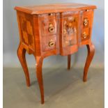 A French style chest, the inlaid shaped top above two marquetry inlaid drawers with brass drop