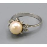 A white gold pearl and diamond set ring, with a large central pearl surrounded by diamonds, ring