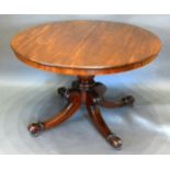 A William IV Mahogany Circular Centre Table with a turned column, outswept legs with carved scroll