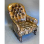 A Victorian Library Armchair with brown leather button upholstered back and seat raised upon