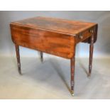 A William IV Mahogany Pembroke Table, the cross banded top above an end drawer opposed by a dummy