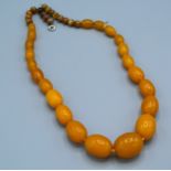 A butterscotch amber graduated bead necklace, 50cms long, approximately 45gms excluding small beads