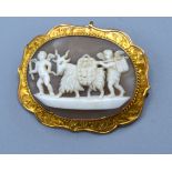 A 9ct gold cameo brooch of oval form, decorated in relief with classical figures, 3cms x 4cms