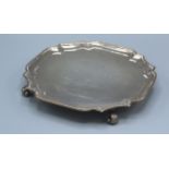 A London Silver Presentation Salver of shaped outline with four scroll feet, 20 cms diameter, 12