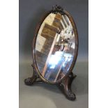 A Late 19th/Early 20th Century Mahogany Table Mirror of oval form with bow cresting and scroll feet,
