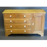 A Pine Side Cabinet with five drawers and a cupboard door raised upon bracket feet, 122 cms wide, 38