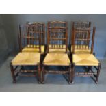 A Set of Six 19th Century Elm Lancashire Spindle Back Dining Chairs with rush seats raised upon