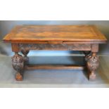 An Oak Refectory Style Draw Leaf Dining Room Table with a carved frieze raised upon four large