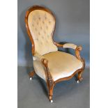 A Victorian Walnut Drawing Room Armchair, the carved shaped and button upholstered back above scroll