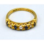 An 18ct. Gold Band Ring set with four sapphires and three diamonds, ring size R, 3.8 gms.