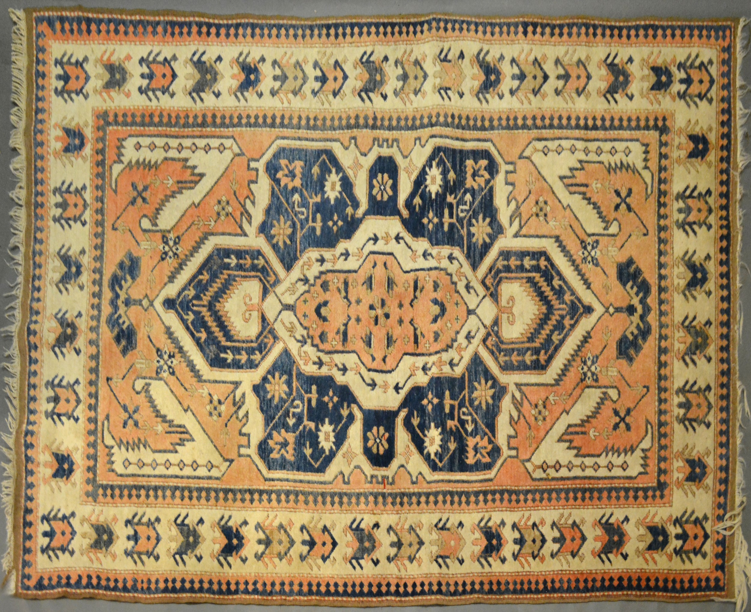 A Turkish Woollen Rug with an all over design upon a terracotta, blue and cream ground within