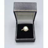 A 9ct. Gold Dress Ring set oval opal type surrounded by cubic zirconia claw set