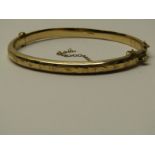 9CT YELLOW GOLD HINGED BANGLE, with safety chain (safety chain in af condition) approximately 7.3