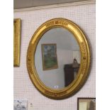 VICTORIAN MIRROR, gilt oval frame hanging wall mirror with applied florette decoration, 24" height