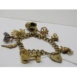9CT YELLOW GOLD CHARM BRACELET, with charms including swan, opening boot, crown, keys, traction