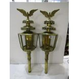 PAIR OF BRASS HEXAGONAL GLAZED CANDLE LANTERNS with brass eagle finials, 27" height