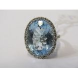 18ct WHITE GOLD BLUE TOPAZ AND DIAMOND RING, principal blue topaz 7 carats surrounded by a halo of