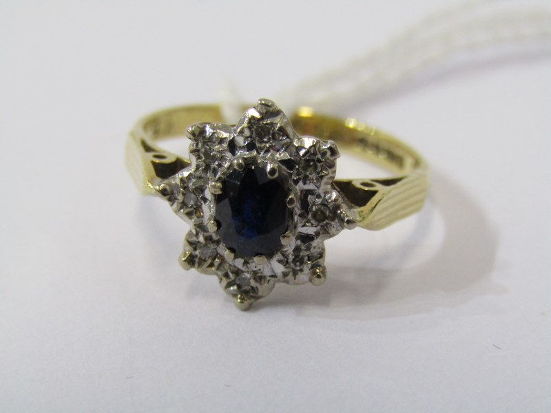 18CT YELLOW GOLD SAPPHIRE & DIAMOND CLUSTER RING, principal oval cut dark blue sapphire surrounded